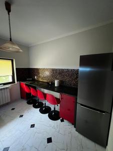 MineriCasa moderna in Mineri的厨房配有红色和黑色的柜台和冰箱。