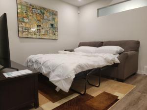 卡尔加里2-Bedroom Guest Suite的一张带白色床单和枕头的床