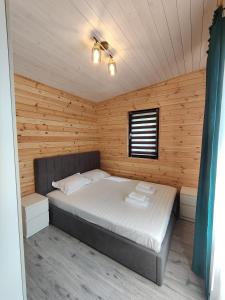 伯伊莱戈沃拉Kub Baile Govora的木制客房内的一间卧室,配有一张床