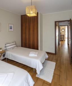 埃斯波森迪Litoral beach Apartment -- Esposende的一间卧室配有两张床和吊灯。