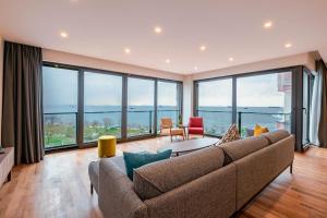 伊斯坦布尔Homie Suites - Newly Built Seaside Apartments on Bakırköy Shore的带沙发和大窗户的客厅