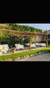 韦尔巴尼亚Hotel Casa Camilla的一个带桌椅和凉亭的花园