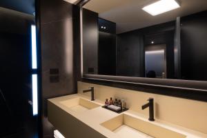 马泰拉La Suite Matera Hotel & Spa的一间带水槽和大镜子的浴室