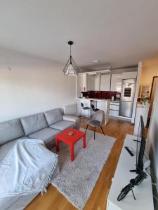 泽尼察Makovi Flat的带沙发和红色桌子的客厅