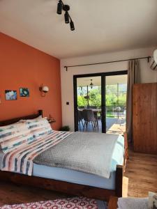 KumlucaADRASAN TATİL EVLERİ 2的一间卧室设有橙色的墙壁、一张床和一个庭院。