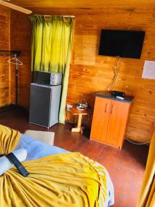 MkuzeIgula lodge的一间卧室配有一张床和一台电视。