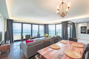 伊斯坦布尔Homie Suites - Newly Built Seaside Apartments on Bakırköy Shore的一间带餐桌的客厅和一间享有海景的客厅