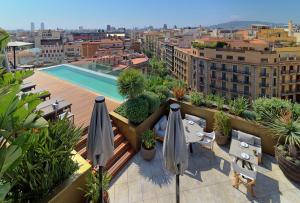 巴塞罗那巴塞罗那第一GL酒店的大楼内带遮阳伞和游泳池的阳台