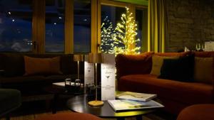 瓦勒迪泽尔Hotel MONT-BLANC VAL D'ISERE的客厅配有桌子和圣诞树