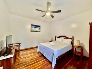 曼巴豪Agoho Resort的一间卧室配有一张床和吊扇