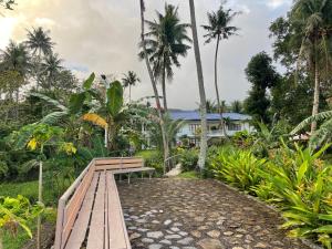 曼巴豪Agoho Resort的棕榈树屋前的木凳