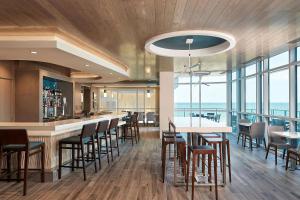 默特尔比奇Hilton Grand Vacations Club Ocean Enclave Myrtle Beach的餐厅设有酒吧,配有桌椅