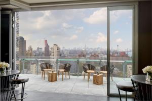 布鲁克林布鲁克林城区汉普顿酒店的设有带桌椅的市景阳台。