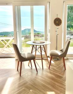 多布拉沃达Bungalow Dream Oasis Dobra Voda的窗户客房内的两把椅子和一张桌子