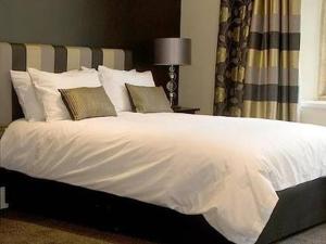 约维尔The Keep Boutique Hotel的卧室配有带枕头的大型白色床