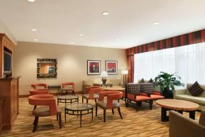 皇后区纽约拉瓜迪亚机场汉普顿酒店的一间备有橙色椅子和桌子的等候室