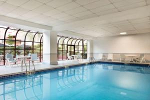 皇后区纽约拉瓜迪亚机场汉普顿酒店的一个带桌椅和窗户的游泳池