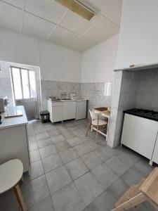 Casa das Memórias的一间大厨房,配有白色的橱柜和一张桌子