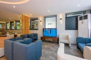 安塔利亚DIAMOND luxury Hotel的一间设有蓝色椅子和平面电视的等候室
