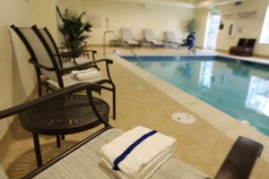 联合市汉普顿酒店联合城市酒店的游泳池旁带两把椅子的游泳池