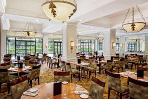 奥卡拉希尔顿奥卡拉酒店的餐厅设有桌椅和窗户。