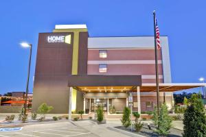 米德韦斯特城Home2 Suites by Hilton OKC Midwest City Tinker AFB的前面有美国国旗的家庭仓库