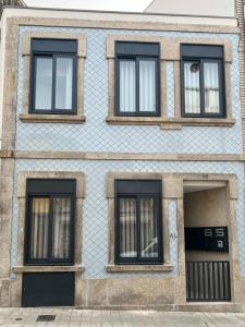 波尔图Coruja’s House AL OPO的蓝色的建筑,有四扇窗户和门