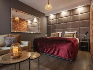 克拉科夫Art Suites Boutique Hotel - Krakow Center的一间卧室配有红色的床和椅子