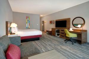 库卡蒙格牧场Hampton Inn & Suites By Hilton Rancho Cucamonga的酒店客房配有一张床、一张书桌和一台电视。