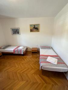 MaterijaHostel on the road trip的客房设有两张床,铺有木地板。