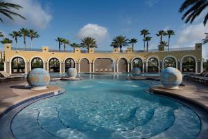 奥兰多Hilton Grand Vacations Club Tuscany Village Orlando的棕榈树建筑中的游泳池
