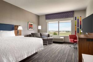 诺曼Hampton Inn & Suites Norman-Conference Center Area, Ok的配有一张床和一台平面电视的酒店客房