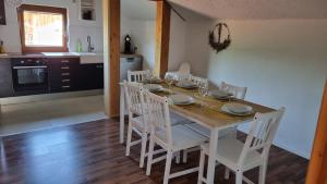 卑尔根Ferienwohnung Bergfreunde的餐桌、白色椅子和厨房