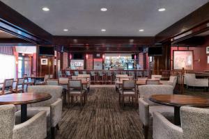 费城费城机场希尔顿逸林酒店的一间带桌椅的餐厅和一间酒吧