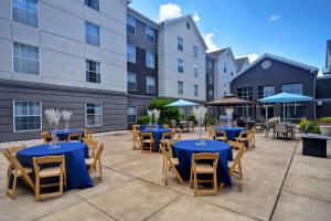 莫尔文费城大峡谷希尔顿惠庭套房酒店的户外庭院配有蓝色的桌椅。