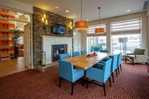 奥克斯福吉谷/奥克斯希尔顿花园酒店的一间带木桌和蓝色椅子的用餐室