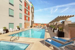 斯科茨Home2 Suites By Hilton Scottsdale Salt River的一张酒店游泳池的图片,游泳池配有桌椅