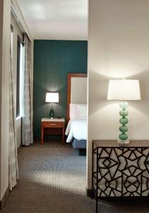 凤凰城凤凰城希尔顿花园酒店的一间卧室配有一张床和一张桌子上的台灯