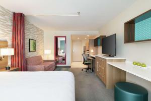 梅萨Home2 Suites By Hilton Mesa Longbow, Az的配有一张床和一张书桌的酒店客房