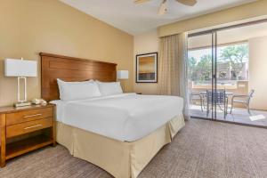 斯科茨Hilton Vacation Club Scottsdale Links Resort的一间带大床的卧室和一个阳台
