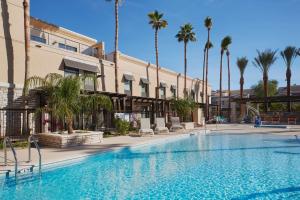斯科茨汉普顿酒店凤凰-斯科茨代尔希亚大道的一座楼前棕榈树游泳池
