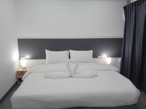 曼谷D Night Suite Hotel的一张白色的大床,上面有两条白色毛巾