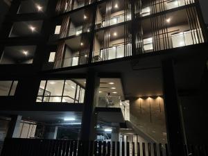 曼谷D Night Suite Hotel的站在建筑物阳台的人