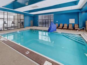 蒙罗维尔匹兹堡门罗维尔希尔顿恒庭酒店的一个带蓝色墙壁和椅子的大型游泳池