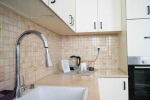 特拉维夫Ajami Guest House的厨房配有白色橱柜和水槽