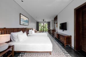 宁平Coco Island Villa & Hotel Ninh Bình的酒店客房设有两张床和电视。