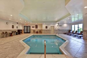 波基普西Homewood Suites By Hilton Poughkeepsie的酒店的大型游泳池配有桌椅