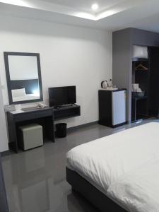 曼谷D Night Suite Hotel的一间卧室配有一张床、一张书桌和一面镜子