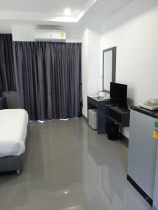 曼谷D Night Suite Hotel的酒店客房,配有床和电视