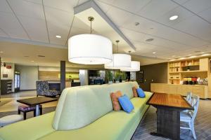 拉皮德城Home2 Suites By Hilton Rapid City的客厅配有绿色沙发和桌子